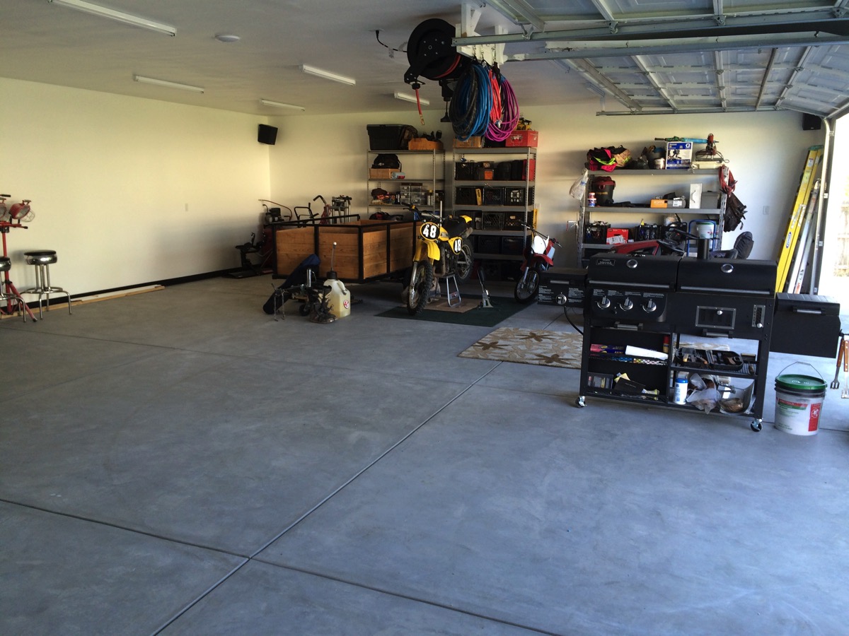 Finished shop interior with motorcycles, shelving, and a grill